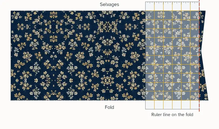 A ruler on the folded fabric with one line on the fold, and the cut along its edge